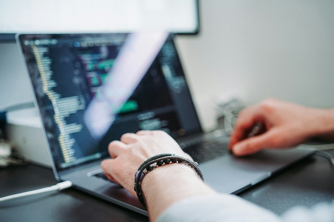 young man coding on laptop